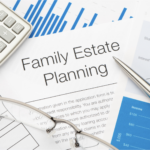 A close-up view of a family estate planning document on a desk, surrounded by a calculator, eyeglasses, a pen, and charts with financial data, symbolizing organization and financial planning.